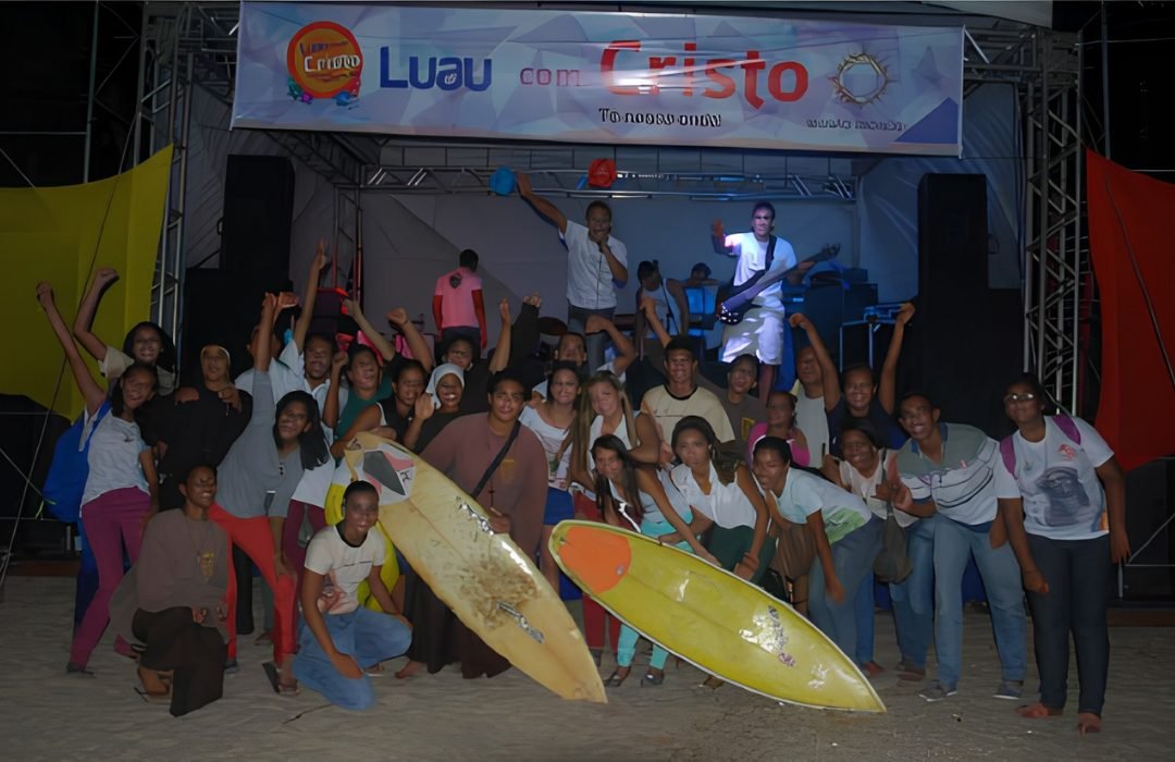 Jovens reunidos com pranchas de surfe diante do palco do Luau com Cristo, nas primeiras edições na praia